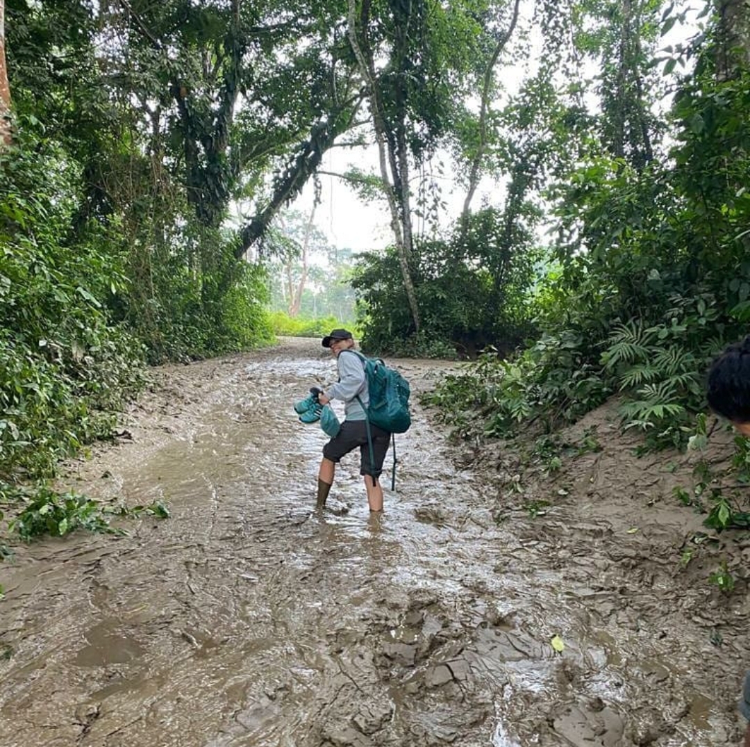 Angy hiking through muddy jungle trail with a backpack
